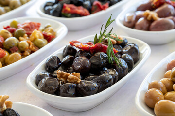 varieties of olives on the plate on a white background