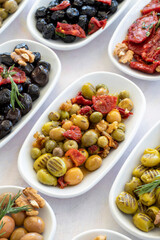 varieties of olives on the plate on a white background