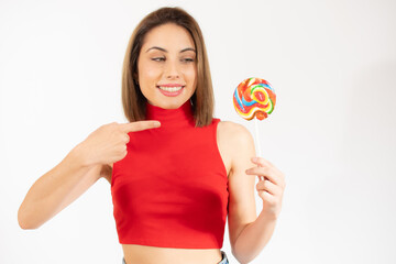 Smiling pretty young woman holding a lollipop isolated over white background