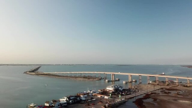 Drone flyover of restaurants and marina near Gulf Intercoastal Waterway shipping channel and JFK Causeway at southern end of Corpus Christi Bay in Texas Texas