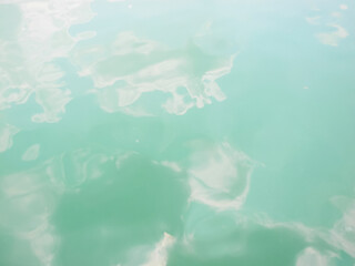 Clouds reflected on the emerald green water surface