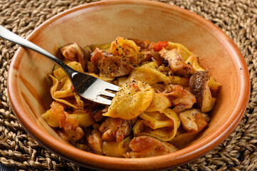 Cheese tortellini with mushrooms in plate on natural matting