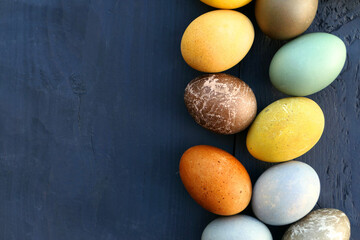 Colorful Easter eggs on dark wooden background. Natural coloring of Easter eggs.