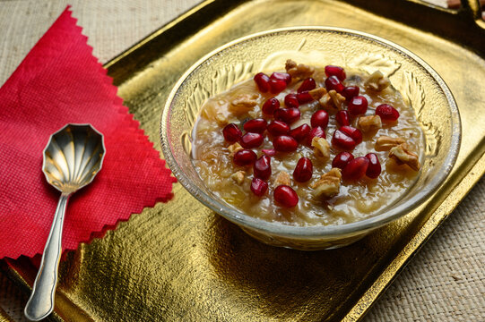 Ashure or Noah's pudding, the turkish dessert porridge in glass bowl on golden dish