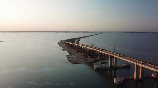 Stationary Aerial view of traffic on JFK Memorial Causeway over the Gulf Intercoastal Waterway and Laguna Madre at sunset; between North Padre Island and Corpus Christi, Texas