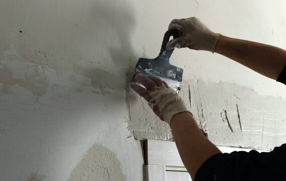 Plastering The Wall Above The Installed Door Frame With A Trowel And Elastic Mortar, Leveling Surface Irregularities During The Renovation Of The Room