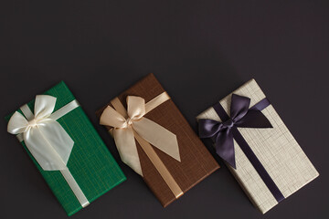 Gift with luxury bow on dark background. Horizontal with copy space.
