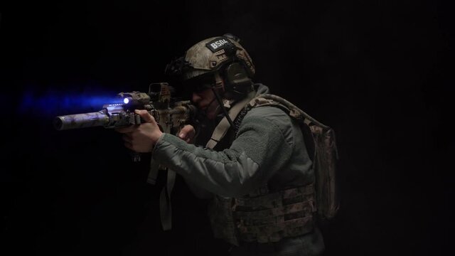 US Special forces soldier aiming with rifle at night in darkness