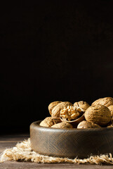 Walnuts on a dark brown wooden background. Nuts are a source of vitamins and vegetable protein. Copy space