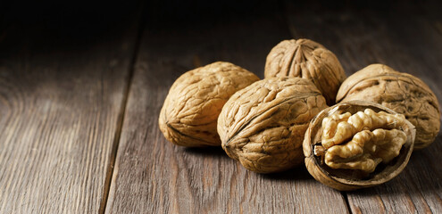 Walnuts on a dark brown wooden background. Nuts are a source of vitamins and vegetable protein. Copy space
