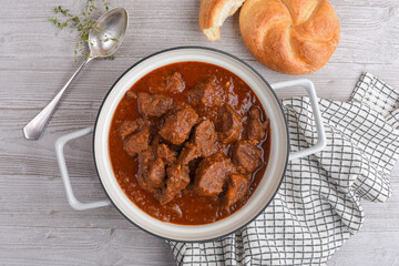 Delicious Viennese beef goulash with Viennese bun - obrazy, fototapety, plakaty