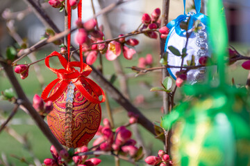 Colorful Easter eggs in brocade cloth hanging from the flower branches, Easter decoration