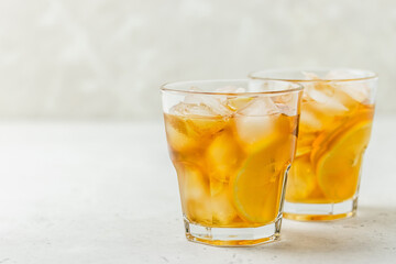 Fototapeta na wymiar Refreshing summer drink, iced lemon ginger tea in glasses. Space for text.