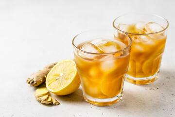 Homemade refreshing drink, iced lemon ginger tea in glasses. Space for text.