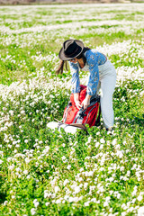 Woman closing her red backpack in the field