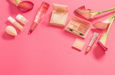 Obraz na płótnie Canvas decorative cosmetics with perfume and flowers on pink background