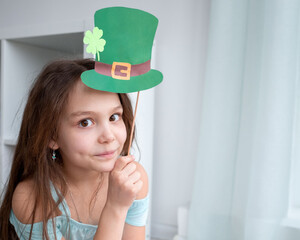 Closeup portrait of a happy preteen caucasian girl in an emerald leprechaun St. Patrick's Day hat