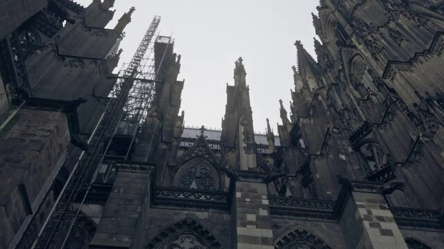 Cologne Cathedral in Germany Left Pan Shot in Winter with Scaffolding on a cloudy day.