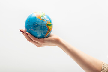 Small globe in a female palm. World in human hands