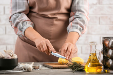 Obraz na płótnie Canvas Woman cutting potatoes in kitchen