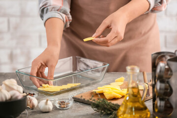 Obraz na płótnie Canvas Woman cooking potato in kitchen