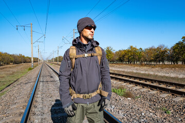 Male traveler with tactical and militari equipment walk alone in sunny day