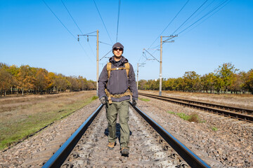 Male traveler with tactical and militari equipment walk alone in sunny day