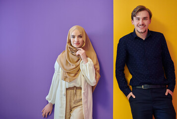 Portrait of happy young muslim couple standing isolated on colorful background