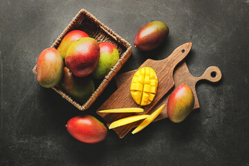 Composition with sweet ripe mangoes on dark background