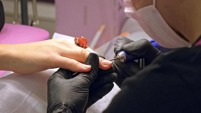 Manicure process. Correction of female nails with drilling machine