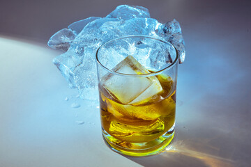 an ice cold frosty glass of liqueur such as scotch or whiskey on blocks of ice with dramatic lighting