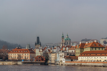 Obraz premium Postcard view of Lesser Town in mist from Charles Bridge,Czech republic.Famous tourist destination.Prague panorama.Foggy morning in city.Amazing European cityscape inversion weather.Romantic trip.