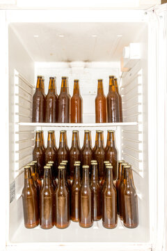 White Fridge Full Of Brown Bottles Of Homemade Beer, Concept Of Home Brewing Or Alcoholism