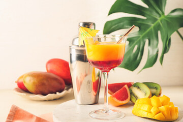 Glass of margarita with mango on table