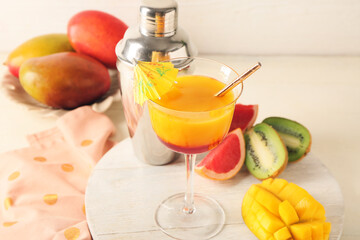 Glass of margarita with mango on table