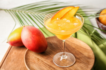 Glass of margarita with mango on table