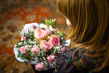 DEFOCUS Woman looking on bunch. A woman admires a gorgeous bouquet. The blonde looks at flower arrangement. Congratulations on Women's Day, Mother's Day, Birthday. Out of focus