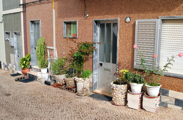 Fototapeta na wymiar Cobbled Street with Decorative Plant Pots and Flowers 
