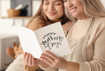 Young woman greeting her mom on Mother's Day at home © Pixel-Shot