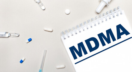 On a light background, a syringe, a stethoscope, vials of medicine, an ampoule and a white notepad...