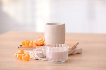 Aroma candles with notebooks and tangerine fruit on table in kitchen