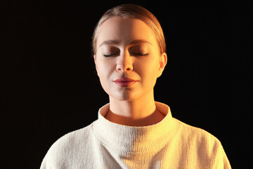 Toned portrait of beautiful young woman on dark background