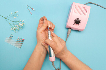 Hardware manicure. Elderly hands. Flat layout. Color background. Nozzles for manicure machine.