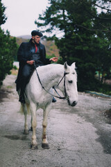 Stylish guy on a white horse