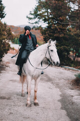 Stylish guy on a white horse