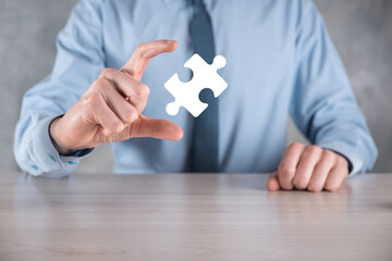 Businessman holds a piece of puzzle jigsaw in his hands.The concept of cooperation, teamwork, help...
