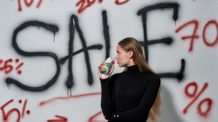 Young woman looking back on wall with sale advertising