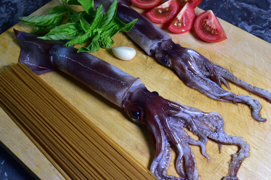 Preparazione di spaghetti tipo chitarra con totani freschi, pomodoro e basilico. Sicilia, Palermo. Cucina tipica 