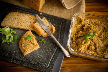 homemade meat pate with bread on a wooden table