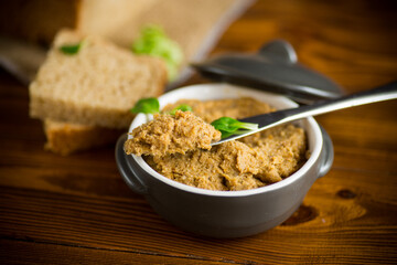 homemade meat pate in a ceramic bowl on a wooden table